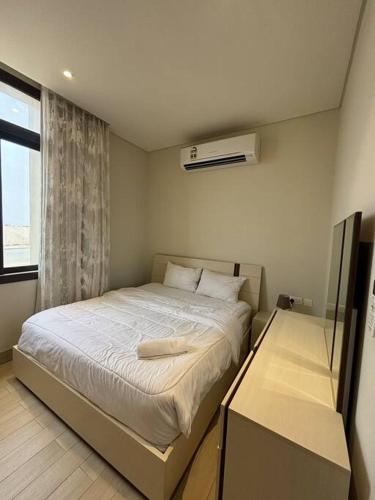 ein kleines Schlafzimmer mit einem Bett mit Fenster in der Unterkunft Hawana Salalah Resort - Riviera 3 in Salalah