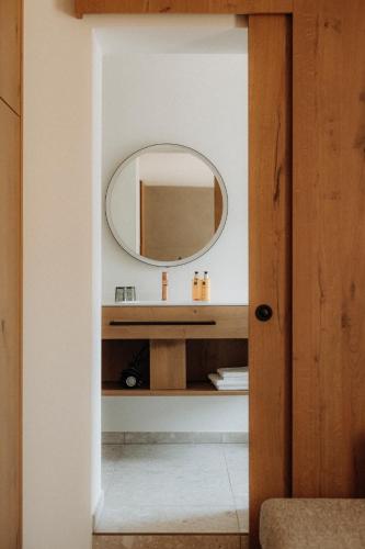 a bathroom with a mirror and a sink at Hotel Salzburg in Saalbach Hinterglemm