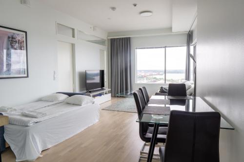 a hotel room with a bed and a table and chairs at 18th Floor Helsinki High Point 1 BDR Apartment with City View - Free Garage Parking in Helsinki