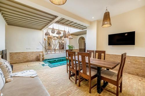 a dining room with a wooden table and chairs at Riad Zatiah Exclusive and chic breakfast incl in Marrakech