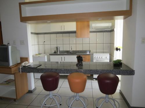 a kitchen with two bar stools and a counter at Green Valley Hotel in Acesita