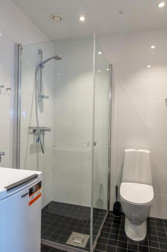 a bathroom with a toilet and a glass shower at 18th Floor Helsinki High Point 1 BDR Apartment with City View - Free Garage Parking in Helsinki