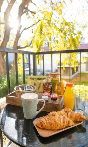 - une table avec un plateau de pâtisseries et une tasse de café dans l'établissement Studio Cozy proche plages, stade, parc chanot, centre, vieux port, à Marseille