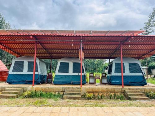 two tents under a metal roof in a parking lot at Trippr Chikkamagaluru in Chikmagalūr