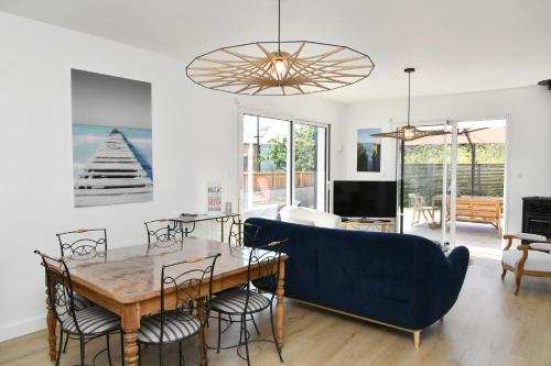 un salon avec une table et un canapé bleu dans l'établissement St Gildas de Rhuys - Maison 10 personnes, 900 m plage, à Saint-Gildas-de-Rhuys