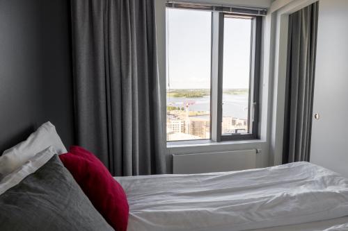 a bedroom with a bed and a large window at 18th Floor Helsinki High Point 1 BDR Apartment with City View - Free Garage Parking in Helsinki