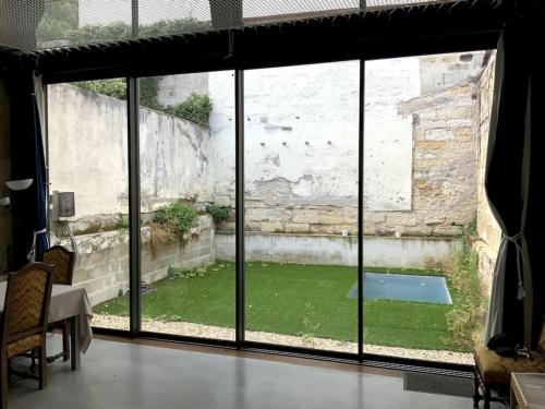 ein Blick auf einen Hof aus einem großen Glasfenster in der Unterkunft Loft Bordeaux Près du Tram in Bordeaux
