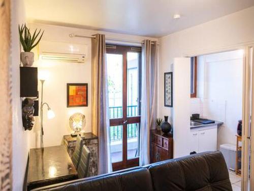 - un salon avec un canapé et une porte donnant sur un balcon dans l'établissement Studio Cozy proche plages, stade, parc chanot, centre, vieux port, à Marseille
