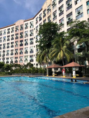 a swimming pool in front of a large building at Viors Staycation in Cainta