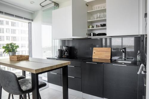 a kitchen with a wooden table and a sink at 18th Floor Helsinki High Point 1 BDR Apartment with City View - Free Garage Parking in Helsinki