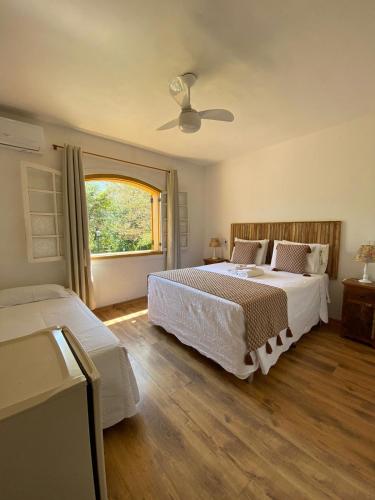 a bedroom with two beds and a window at Pousada Pe da Serra in Tiradentes
