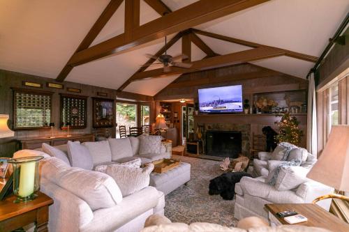 a living room with white couches and a fireplace at Hinesight at Hound Ears in Valle Crucis