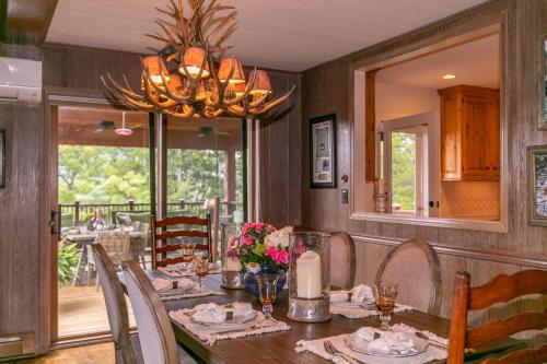 a dining room with a table and a chandelier at Hinesight at Hound Ears in Valle Crucis
