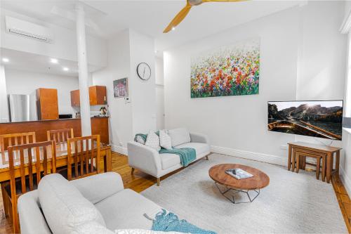a living room with a couch and a table at Flinders Lane Apartments in Melbourne