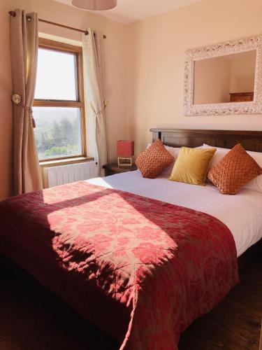 a bedroom with a large bed with a red blanket at No 10 Coastguard Station in Renvyle