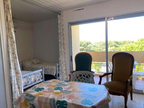 Cette chambre comprend un lit, deux chaises et une table. dans l'établissement Appartement T1 avec balcon, climatisation et parking à Balaruc-les-Bains - FR-1-553-267, à Balaruc-les-Bains
