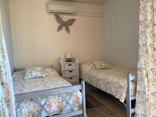 - 2 lits dans une chambre avec un papillon sur le mur dans l'établissement Appartement T1 avec balcon, climatisation et parking à Balaruc-les-Bains - FR-1-553-267, à Balaruc-les-Bains