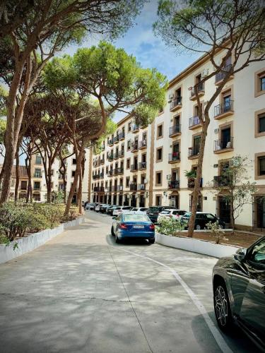 a street with cars parked in front of tall buildings at Home 120, Mansion Alhamar in Sitio de Calahonda