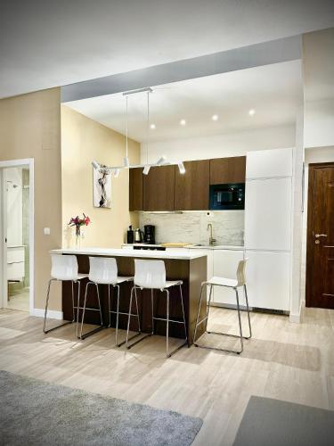 a kitchen with a large white counter and chairs at Home 120, Mansion Alhamar in Sitio de Calahonda