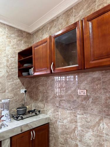 a kitchen with wooden cabinets and a counter top at Luxurious apartment complex in New Weija