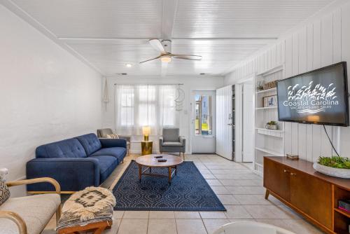 a living room with a blue couch and a tv at KDH187 Lunar Tide in Kill Devil Hills