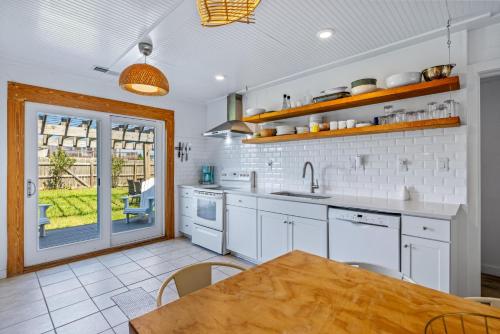 a kitchen with white cabinets and a wooden table at KDH187 Lunar Tide in Kill Devil Hills