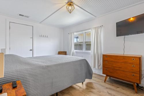 a bedroom with a bed and a dresser and a television at KDH187 Lunar Tide in Kill Devil Hills