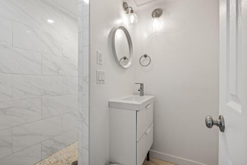 a white bathroom with a sink and a mirror at KDH187 Lunar Tide in Kill Devil Hills