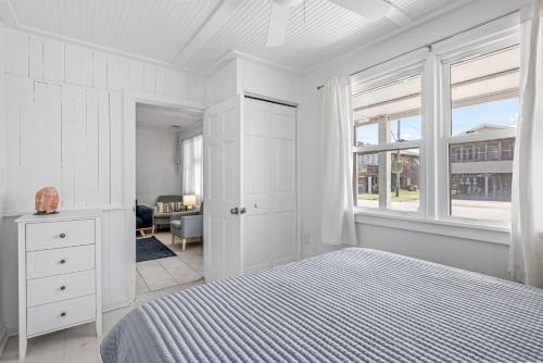 a white bedroom with a bed and a window at KDH187 Lunar Tide in Kill Devil Hills
