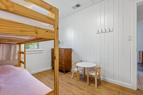 a bedroom with a bunk bed and a table and chairs at KDH187 Lunar Tide in Kill Devil Hills