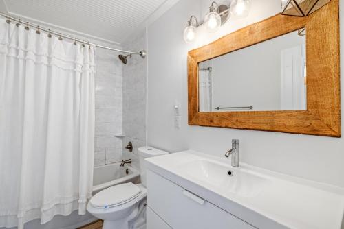 a white bathroom with a sink and a mirror at KDH187 Lunar Tide in Kill Devil Hills