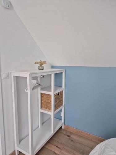 - une table de chevet blanche avec un panier dans l'établissement Logement neuf tout équipé, au Havre