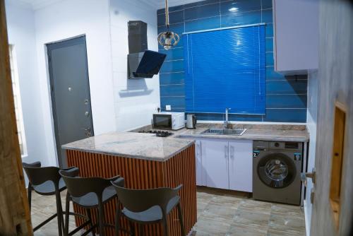 a kitchen with a sink and a washing machine at Freda's place, Luxurious 2 bed with 247 electricity and PS5 in Lekki