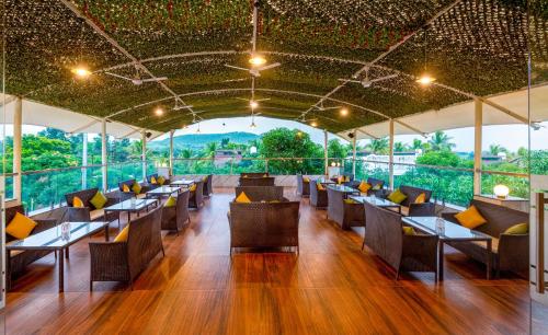 a restaurant with tables and chairs with a view at Freesia Resort by Express Inn in Nashik