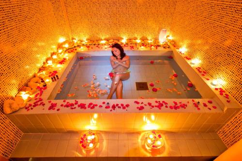 a woman sitting in a bath tub filled with flowers at Poseidon Palace in Leptokaria