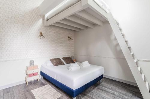 une petite chambre avec un lit et un escalier dans l'établissement House for 18 people with cinema Place Morny, à Deauville