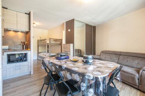 un salon avec une table avec des chaises et un canapé dans l'établissement Régliss - Pour 6p station ski accessible à pied, à Chamrousse