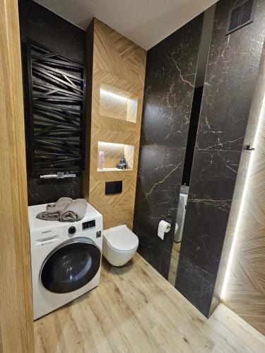 a bathroom with a washing machine and a toilet at apartament mono loft in Ełk