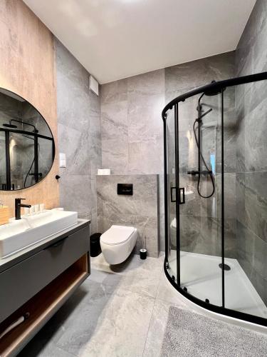 a bathroom with a shower and a toilet and a sink at Marina Augustów - BRYZA in Augustów