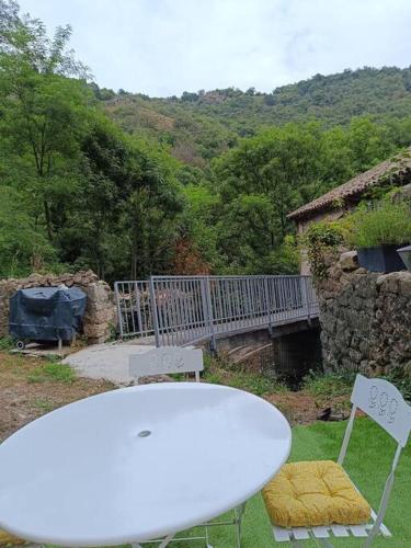 a white table and two chairs in a yard at Appartement 2 à 4 personnes in Antraigues