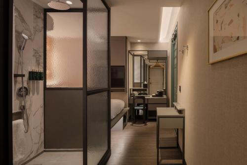 a small room with a bedroom and a bathroom at Claude Hotel in Singapore
