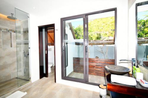 a bathroom with a glass shower and a sink at Villa Ayapana in Le Morne