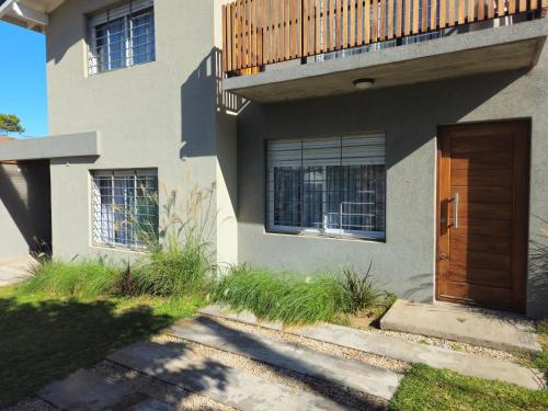 a house with a wooden door and a balcony at Dúplex Familiar Av 5 y Paseo 117 in Villa Gesell