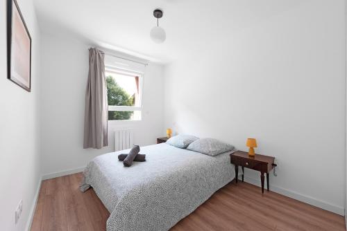 une chambre blanche avec un lit et une fenêtre dans l'établissement L'Armagnac T2 proche gare avec parking gratuit, à Toulouse