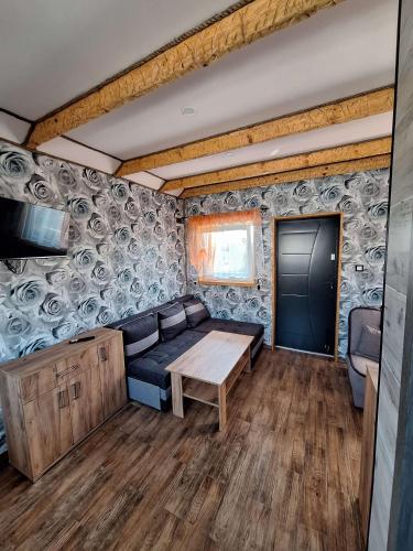a living room with a couch and a table at Domki U Joanny - Sarbinowo 900 m do morza in Sarbinowo