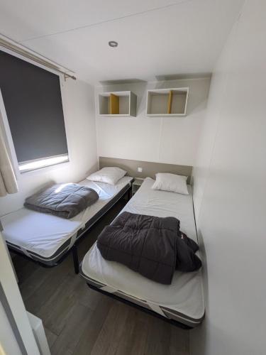 Un pat sau paturi într-o cameră la Mobil home 4x8m et terrasse 18m2