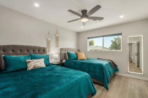 a bedroom with two beds and a ceiling fan at 4 Brdm 6 Beds Pool PetsOK Fenced Yard in Scottsdale