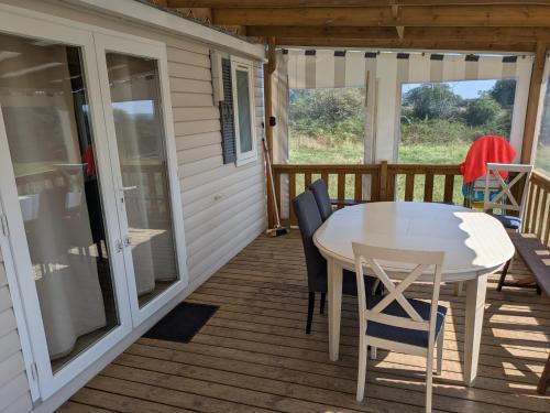 une table et des chaises sur le pont d'une cabine dans l'établissement Mobil home 4x8m et terrasse 18m2, à Évrunes