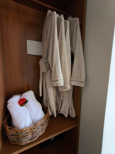 a towel rack with towels and a basket of towels at Almareia Boutique Hotel in Praia dos Carneiros