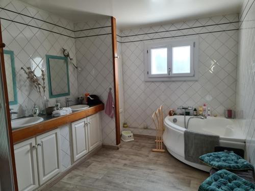 une salle de bain avec une baignoire et un lavabo dans l'établissement Maison de vacances en pierre avec piscine, à Saint-Mard